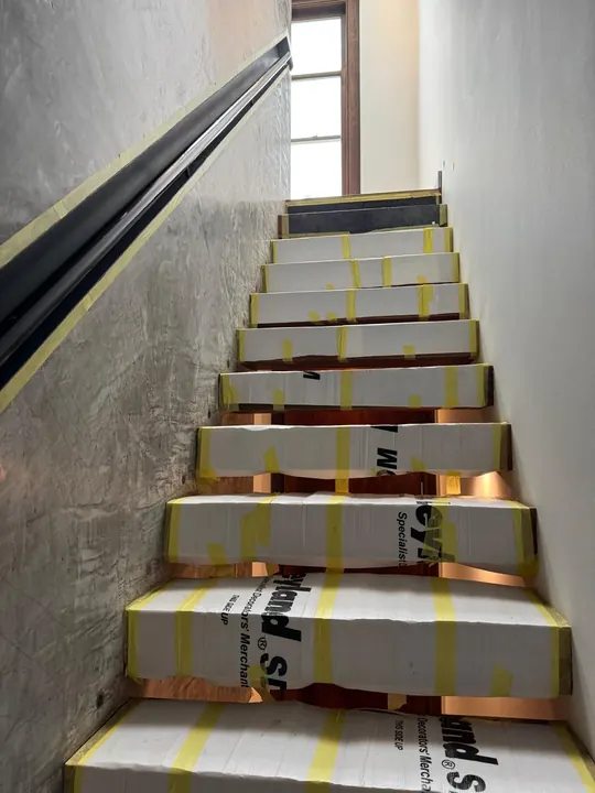 A basement staircase with its treads protected during construction